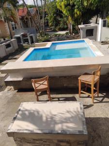 una piscina con due sedie e un tavolo di The Dream Nest at Csompó Silver Manor a St Mary