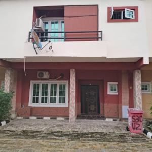 a red and white house with a door and a balcony at Peace in Lekki