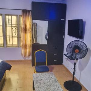 a living room with a fan and a black cabinet at Peace in Lekki +9 photos