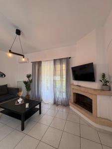 a living room with a flat screen tv on a wall at Irène House in Egina