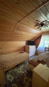 a bedroom with two beds in a wooden room at Elizabeth in Mykulychyn