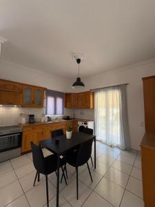 a kitchen with a table and chairs in a kitchen at Irène House in Egina