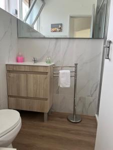 a bathroom with a toilet and a sink and a mirror at Sintra Sol - Apartamentos Turisticos in Sintra