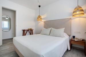 a bedroom with a white bed and two pendant lights at Casa Sunrise in Parque Holandes +25 photos