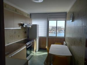 a kitchen with a table and a table and a window at Puerto de Burela in Burela de Cabo