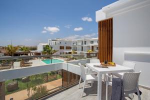 a balcony with a table and chairs and a swimming pool at Casa Sunrise in Parque Holandes