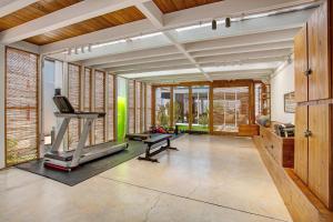 a room with a gym with a treadmill and windows at Casa Sunrise in Parque Holandes