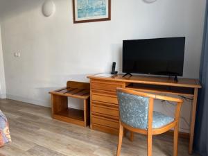 a room with a desk with a television and a chair at Sintra Sol - Apartamentos Turisticos in Sintra