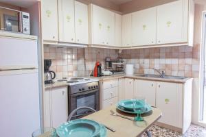 a kitchen with white cabinets and a table with plates on it at Amaryllis in Gythio