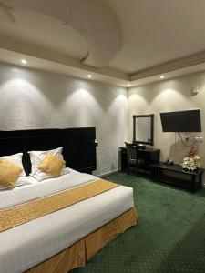 a hotel room with a large bed and a desk at كيان الين للشقق المخدومة -حياة ايليت سابقا in Abha +31 photos