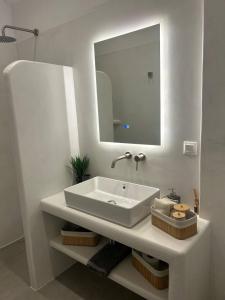 un bagno bianco con lavandino e specchio di Almires 1-Stay 20m from Aegean Sea a Cherronisos