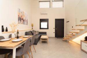 a dining room and living room with a table and a couch at Ikaros City Loft in Chania Town