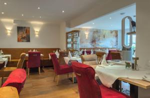 a restaurant with red chairs and tables in a room at Hotel Restaurant Traube Kallstadt in Kallstadt