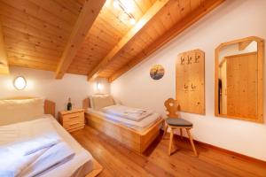 two beds in a room with wooden ceilings at Schöneben Chalet Steinlinge in Wald im Pinzgau +42 photos