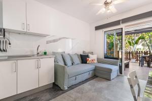 Una cocina y una sala de estar con un sofá y una mesa. en Home2Book Relaxing Stay & Terrace in Maspalomas, en Maspalomas