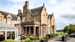 an old house with a car parked in front of it at Norton House Hotel & Spa, Edinburgh in Ingliston