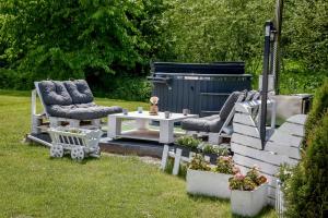 a backyard with two chairs and a table and two chairs and a table sidx sidx at Domki Perła Białki z Jacuzzi in Białka Tatrzańska