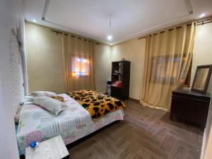 a bedroom with a bed with a cheetah blanket at Villa cherif in Chouiter +16 photos