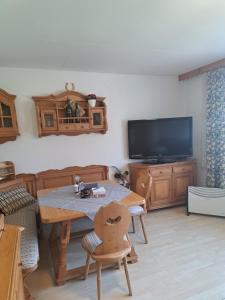 a living room with a table and a flat screen tv at Haus beim Wasser im grünen in sehr ruhiger Lage!! in Willersbach