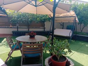 a patio table and chairs under an umbrella at Casa Alessia in Catania