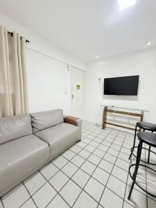 a living room with a couch and a flat screen tv at APARTAMENTO NO MELHOR DE BOA VIAGEM in Recife