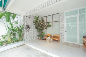 a porch with plants and a glass door at 大樹林 Mori Mori 包棟民宿 寵物友善 附車位 in Tainan