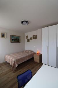 a bedroom with a bed and a blue chair at Appartamento al Sole in Paderno del Grappa