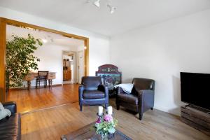 a living room with two chairs and a flat screen tv at Alfreds Landidyll in Weddingstedt