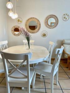 a white dining room table with white chairs and mirrors at Beautiful Apartment Alfaz del Sol in Alfaz del Pi