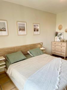 a bedroom with a large white bed and a dresser at Beautiful Apartment Alfaz del Sol in Alfaz del Pi