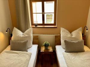 two beds in a room with a window at Gassentraum NEU mit Balkon in Pirna