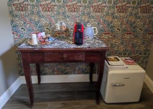 a table with a coffee maker on it next to a refrigerator at Casetta Morris in Valdobbiadene +6 photos