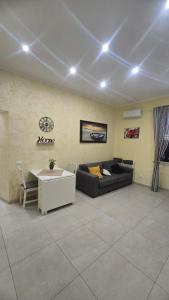 uma sala de estar com um sofá e uma mesa em Casetta Delia em Palermo