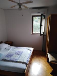 a bedroom with a bed and a window at Villa Milas - Apartman 04 in Tkon +3 photos