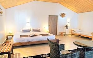 a bedroom with a bed and a table and chairs at Savannah Beach in Ambatomilo