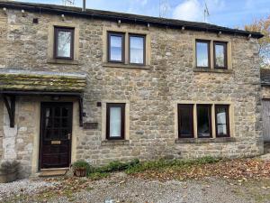 a stone house with windows and a door at 3 Bedroom Dog Friendly Cottage with Off Lead Field in Airton