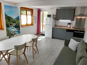 a kitchen and living room with a table and chairs at Gîte 829 Montagnes du Jura avec Spa et Sauna classé 3 étoiles in Foncine-le-Haut