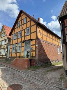 a yellow and orange house with a brick building at Modernes Stadtwohnen im charmanten Fachwerk, Mindestaufenthalt 3 Tage in Plau am See
