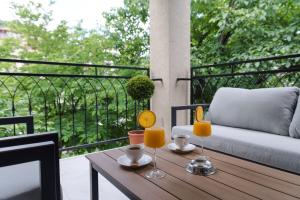 a table with two glasses of orange juice on a balcony at Vila Dara in Vrnjačka Banja