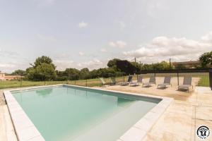 ein Pool mit Liegestühlen um ihn herum in der Unterkunft Les amandiers du casteras in Saint-Clar-de-Rivière