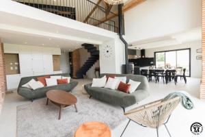 ein Wohnzimmer mit zwei Sofas und einem Tisch in der Unterkunft Les amandiers du casteras in Saint-Clar-de-Rivière