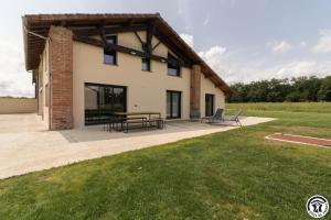 Blick auf ein Haus mit einer Terrasse in der Unterkunft Les amandiers du casteras in Saint-Clar-de-Rivière