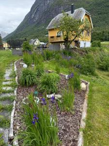 a garden in front of a house with flowers at Naustvoll in Olden