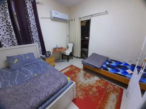 una camera con 2 letti e una scrivania con sedia di Yasliving EXTN a Abu Dhabi