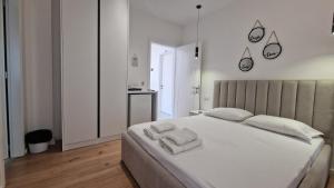 a bedroom with a white bed with towels on it at JD villa in Vlorë