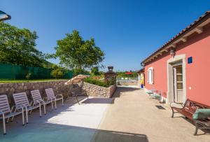 un patio con sillas y una pared en Villa Maslina, a charming and private villa 15 km from the sea, en Pićan