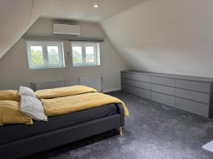 a bedroom with a bed with yellow sheets and windows at Modernes Stadtwohnen im charmanten Fachwerk, Mindestaufenthalt 3 Tage in Plau am See