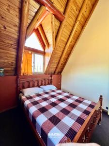 una cama en una habitación con techo de madera en Natasha Hostel Boutique, en Caviahue 10 fotos más