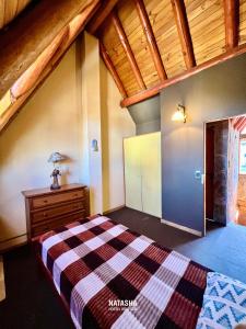 Un dormitorio con una cama y un techo de madera. en Natasha Hostel Boutique, en Caviahue