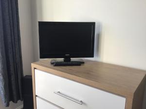a computer monitor sitting on top of a dresser at The Annexe in Isle of Wight +2 photos